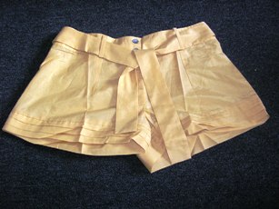 SHORT POUR FEMMES EN TISSU DE COTON MAJORITAIRE (70% COTON, 30% SOIE) DE FACTURE FLUIDE ET AMPLE, UNICOLORE, DONT LA TAILLE COMPORTE UN BIAIS AVEC DES PASSANTS, AVEC UNE OUVERTURE PARTIELLE SUR LE DEVANT FERMANT DROITE SUR GAUCHE PAR BOUTONS, AVEC UNE CEINTURE DANS LA MEME ETOFFE. LA BASE EST OURLEE ET COMPORTE DES PLIS.  

TAILLE 2.