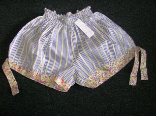 SHORT POUR FEMMES EN TISSU DE COTON (100% COTON), IMPRIME DE RAYURES, AVEC UNE BANDE DE SMOCKS A LA TAILLE (ENVIRON 4 CM DE LARGE), AVEC UNE FENTE DE CHAQUE COTE, AVEC UN BIAIS IMPRIME FLEURI (ENVIRON 2,5 CM DE LARGE) A LA BASE DE CHAQUE JAMBE A NOUER SUR LES COTES AU NIVEAU DE LA FENTE.

TAILLE 2.