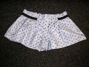 SHORT COURT POUR FEMMES EN TISSU DE COTON IMPRIMÉ (86% COTON-14% SOIE) POSSEDANT UN ELASTIQUE ET DES FRONCES A LA TAILLE ET AVEC UN EMPIECEMENT DE TISSU DE COULEUR UNIE SUR LES HANCHES.