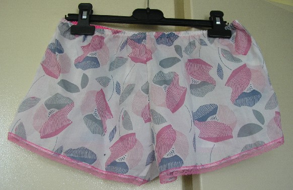PETIT SHORT D’INTERIEUR POUR FEMME, EN TISSU DE COTON (100% COTON), AVEC UN ELASTIQUE A LA TAILLE, SANS OUVERTURE SUR LE DEVANT, SANS FOND INTERNE A L’ENTREJAMBE, AVEC UNE FENTE DE CHAQUE COTE, AVEC UN GALON DE DENTELLE A LA BASE.