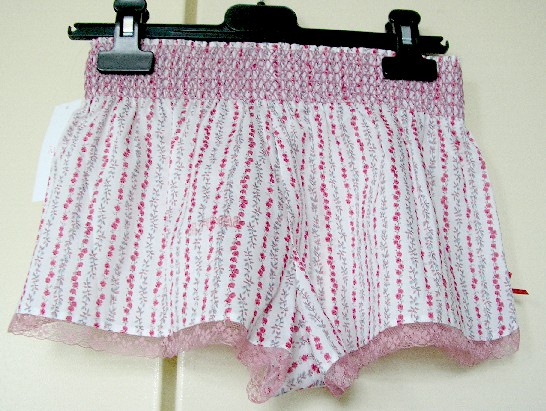 SOUS-VETEMENT SE PRESENTANT SOUS LA FORME D’UNE CULOTTE, GENRE SHORTY, EN TISSU DE COTON (100% COTON), DESTINE A COUVRIR LA PARTIE INFERIEURE DU CORPS, COMPORTANT UNE BANDE ÉLASTIQUEE À LA TAILLE FORMANT DES SMOCKS, AVEC UNE DOUBLURE À L'ENTRE-JAMBES, SANS OUVERTURE SUR LE DEVANT, AVEC UNE PETITE FENTE DE CHAQUE COTE DOTEE D’UN GALON EN DENTELLE, AVEC UN GALON EN DENTELLE A LA BASE.