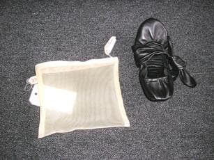 CHAUSSURE D'INTERIEUR POUR FEMME, UNICOLORE, NE COUVRANT PAS LA CHEVILLE, A DESSUS EN CUIR, DONT LA SEMELLE EXTERIEURE EST CONSTITUEE D'UNE PIECE ETROITE EN CAOUTCHOUC COLLEE SUR UNE SEMELLE INTERMEDIAIRE SOUPLE EN CUIR DEBORDANT SUR LE POURTOUR DE LA SEMELLE EXTERIEURE , POSSEDANT UN ELASTIQUE SUR LE POURTOUR DE LA CHAUSSURE ET UN NOEUD DECORATIF A NOUER AUTOUR D'UNE PATTE SUR LE DESSUS A L'AVANT.   CETTE CHAUSSURE D'INTERIEUR EST PRESENTEE DANS UNE POCHETTE TRANSPARENTE EN MATIERE TEXTILE TRANSPARENTE SOUPLE, DE FORME RECTANGULAIRE, MUNIE D'UNE FERMETURE A GLISSIERE.