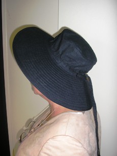CHAPEAU SOUS LA FORME D'UNE CAPELINE CONFECTIONNE EN TISSU DE LIN MAJORTAIRE (55% LIN, 45% COTON), DOUBLE, FABRIQUE PAR ASSEMBLAGE DE BANDES DOTEES DE SURPIQURES, MUNI D'UN LIEN A NOUER.