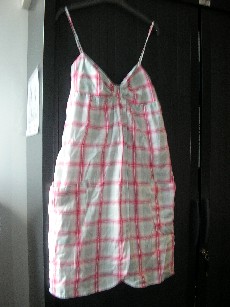 VETEMENT DESTINE A RECOUVRIR LE CORPS, GENRE ROBE POUR FEMMES, CONFECTIONNE EN TISSU 100% COTON, D'UNE LONGUEUR DE 90 CM POUR UNE TAILLE S, DE FORME AMPLE, AVEC UNE DOUBLURE COMPLETE, COMPORTANT UNE ENCOLURE EN V, DES FRONCES PARTANT DU DESSOUS DE LA POITRINE, DE FINES BRETELLES REGLABLES, LE HAUT DU DOS EST AVEC DES SMOCKS, UNE OUVERTURE PARTIELLE SUR LE DEVANT AU MILIEU DONT LES PANS SE CROISENT, UNE POCHE DE CHAQUE COTE DU VETEMENT, LA BASE DU VETEMENT ET LA BORDURE DE L'OUVERTURE SE TERMINENT PAR UN OURLET.