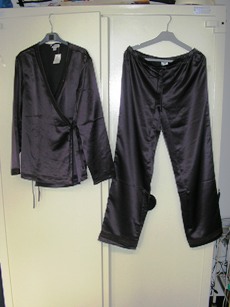 PYJAMA POUR FEMMES CONFECTIONNE EN TISSU DE FIBRES SYNTHETIQUES (100% POLYESTER), D'ASPECT SATINE, COMPOSE DE DEUX VETEMENTS ASSORTIS, DE FACTURE AMPLE ET FLUIDE, DE MEME COULEUR ET SANS ELEMENT D'INCONFORT, COMPRENANT :  

- UN VETEMENT DESTINE A RECOUVRIR LA PARTIE SUPERIEURE DU CORPS, GENRE VESTE, DESCENDANT AUX HANCHES, COMPORTANT DES MANCHES LONGUES BORDEES D'UN GALON TRANSPARENT AVEC UNE BRODERIE ET DES STRASS COUSUS, UNE OUVERTURE COMPLETE SUR LE DEVANT AVEC LE MEME GALON SUR SON POURTOUR, UN JEU DE QUATRE CORDONS A NOUER PERMETTANT DE FERMER LA VESTE DROITE SUR GAUCHE, ET UNE FENTE DE 12 CM ENVIRON DE CHAQUE COTE DE LA BASE.  

- UN PANTALON DESCENDANT JUSQU'AUX CHEVILLES EN ENVELOPPANT SEPAREMENT CHAQUE JAMBE , SANS OUVERTURE, AVEC UN ELASTIQUE A LA TAILLE SE PROLONGEANT PAR UN LIEN A NOUER SUR LE DEVANT. LA BASE COMPORTE UN GALON IDENTIQUE A LA VESTE. 

TAILLE 40