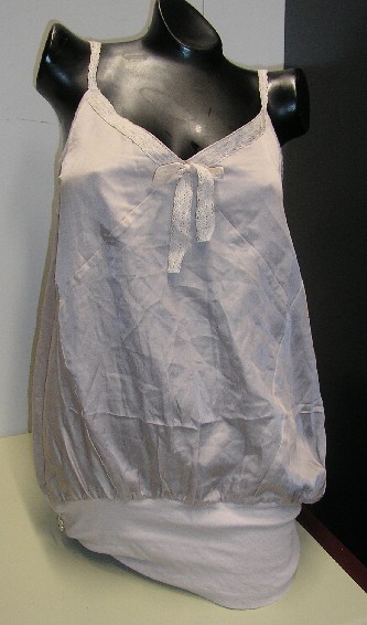 VETEMENT COMPOSITE POUR FEMME, DE STYLE BLOUSE-CARACO, DE FACTURE AMPLE ET FLUIDE, TRES ELABOREE, EN TISSU DE SOIE (55% SOIE- 45% COTON) DESTINE A COUVRIR LA PARTIE SUPERIEURE DU CORPS, DESCENDANT JUSQU’AUX HANCHES, AVEC DEUX FINES BRETELLES REGLABLES EN DENTELLE, AVEC UNE ENCOLURE EN V DOTEE SUR SON POURTOUR D’UN GALON EN DENTELLE SE PROLONGEANT PAR UN NŒUD DECORATIF, AVEC UN LARGE BORD COTES EN ETOFFE DE BONNETERIE RESSERRANT LA BASE ET PERMETTANT UN EFFET BOUFFANT.