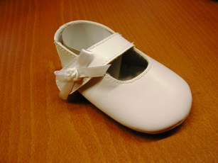 CHAUSSURE POUR BEBE, GENRE BALLERINE, AVEC UN DESSUS EN MATIERE PLASTIQUE COUVRANT PARTIELLEMENT LE DESSUS DU PIED,  AVEC UNE BRIDE FERMANT PAR BANDE VELCRO, AVEC UNE DOUBLURE EN MATIERE TEXTILE, AVEC UNE SEMELLE EXTERIEURE EN MATIERE TEXTILE, AVEC UN RUBAN ET UNE FLEUR EN RUBAN COUSU SUR LA BRIDE DU COTE EXTERIEUR  DE LA CHAUSSURE.