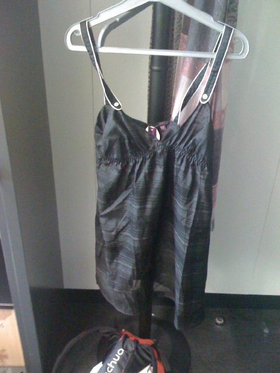 VETEMENT POUR FEMMES DESTINÉ À RECOUVRIR LA PARTIE SUPÉRIEURE DU CORPS, LEGER, DE FACTURE AMPLE, EN TISSU DE SOIE MAJORITAIRE (67% SOIE ET 33% COTON), LEGEREMENT TRANSPARENT, DE TYPE BLOUSE SANS MANCHES, AVEC DEUX BRETELLES SE FERMANT AU MOYEN DE DEUX BOUTONS BLANCS, DESCENDANT JUSQU'AU-DESSUS DE LA MI-CUISSE.
CE VÊTEMENT PRÉSENTE UNE ENCOLURE EN V, UNE OUVERTURE COMPLETE DANS LE DOS SE FERMANT DROITE SUR GAUCHE AU MOYEN DE SEPT BOUTONS ET UNE BANDE ELASTIQUE SOULIGNANT LA POITRINE. LA BASE DU VETEMENT EST OURLEE.
LONGUEUR: ENVIRON 80CM
