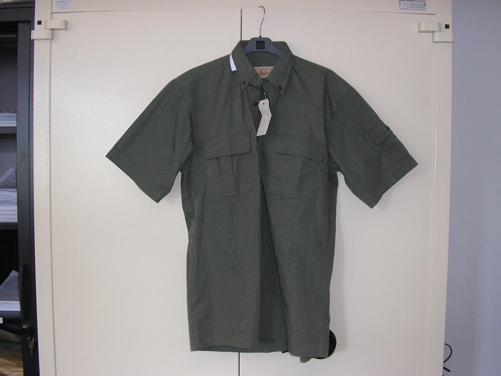 CHEMISETTE POUR HOMME EN TISSU MAJORITAIRE DE FIBRES SYNTHÉTIQUES (65% POLYESTER,35% COTON),DESCENDANT SUR LES HANCHES, AVEC UNE OUVERTURE COMPLÈTE SUR LE DEVANT SE FERMANT GAUCHE SUR DROITE AU MOYEN DE BOUTONS, AVEC UN COL RABATTU, AVEC DEUX POCHES POITRINE FERMÉES PAR VELCROS, AVEC DES MANCHES COURTES (LA MANCHE GAUCHE EST POURVUE D'UNE POCHE SUR L'EPAULE), AVEC UN LÉGER OURLET A LA BASE.
LA CHEMISETTE COMPORTE UN PLI D'AISANCE DANS LE DOS. 

TAILLE M