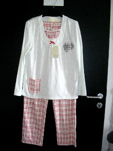 PYJAMA POUR FEMMES, CONFECTIONNE EN ETOFFE DE BONNETERIE 60% COTON ET 40% POLYESTER, COMPOSE DE DEUX VETEMENTS:

-UN VETEMENT DESTINE A RECOUVRIR LA PARTIE SUPERIEURE DU CORPS, DE FORME AMPLE, DE COLORIS UNI, COMPORTANT UNE ENCOLURE ARRONDIE, DES MANCHES LONGUES DONT LES EXTREMITES SE TERMINENT PAR UN OURLET, UNE POCHE AU BAS DU VETEMENT COTE DROIT, UN OURLET A LA BASE DU VETEMENT, AVEC DES MOTIFS BRODES AU NIVEAU DE LA POITRINE COTE GAUCHE, UN PLASTRON AVEC UNE FAUSSE OUVERTURE PAR BOUTON AU NIVEAU DE LA POITRINE, UN PETIT NOEUD AU CENTRE DE L'ENCOLURE ET DES FRONCES PARTANT DU CENTRE DE LA POITRINE, LE PLASTRON, LA POCHE ET UN MOTIF BRODERIE SONT ASSORTIS AU PANTALON.

-UN PANTALON SANS OUVERTURE, COMPORTANT UNE TAILLE ELASTIQUEE, UN OURLET A LA BASE DES JAMBES.