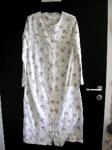 VETEMENT DESTINE A RECOUVRIR LE CORPS, POUR FEMMES, GENRE PEIGNOIR D'INTERIEUR, CONFECTIONNE EN ETOFFE DE BONNETERIE 100% COTON, AVEC DES MOTIFS FLEURIS IMPRIMES, D'UNE LONGUEUR DE 115 CM, COMPORTANT UNE ENCOLURE ARRONDIE, UNE OUVERTURE COMPLETE SUR LE DEVANT AU MILIEU AVEC DES BOUTONS SE FERMANT DE DROITE SUR GAUCHE, DES MANCHES LONGUES DONT LES EXTREMITES SE TERMINENT PAR UN OURLET, LA BASE DU VETEMENT SE TERMINE PAR UN OURLET, AVEC POUR DECORATION DES PETITS PLIS ET UN PETIT NOEUD AU NIVEAU DE LA POITRINE.