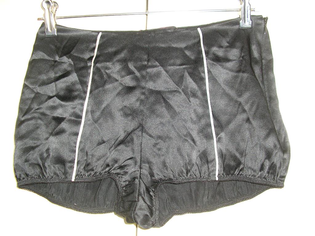 PETIT SHORT D’INTÉRIEUR POUR FEMMES CONFECTIONNÉ EN TISSU DE SOIE (100%), DE FACTURE AMPLE ET FLUIDE, SE FERMANT A L'AIDE D'UNE FERMETURE A GLISSIÈRE SUR LE COTÉ GAUCHE, AVEC UN ÉLASTIQUE A LA BASE DES CUISSES ET SANS FOND INTERNE A L’ENTREJAMBE. LE SHORT PRÉSENTE 4 LISERETS BLANCS VERTICAUX.