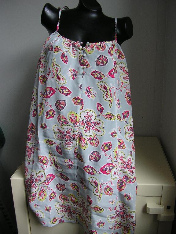 ROBE CONFECTIONNÉE EN TISSU DE SOIE (100%), DE FACTURE AMPLE ET FLUIDE, DESTINÉE A COUVRIR LE CORPS, DESCENDANT JUSQU'AU DESSUS DES GENOUX, DÉPOURVUE DE MANCHES, AVEC DES BRETELLES TRÈS FINES A NOUER, AVEC UNE ENCOLURE DROITE, AVEC UNE OUVERTURE PARTIELLE SOUS L'ENCOLURE SE FERMANT DROITE SUR GAUCHE A L'AIDE DE 6 PETITS BOUTONS, AVEC UN BIAIS FANTAISIE SUR LE POURTOUR DU VÊTEMENT ET DES FRONCES DÉCORATIVES SOUS L'ENCOLURE ET AU DOS. EN OUTRE, LA BASE DU VÊTEMENT EST OURLÉE.

LONGUEUR : 92 CM
TAILLE : 40