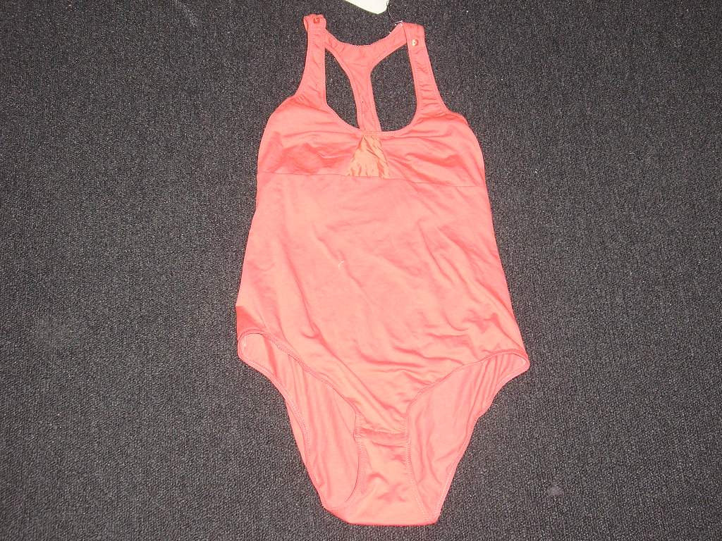 VÊTEMENT POUR FEMME,PRES DU CORPS,DE TYPE BODY,EN ETOFFE DE BONNETERIE DE COTON MAJORITAIRE(91% COTON,8% ELASTHANNE) AVEC DE FINES BRETELLES POURVUES DE BOUTONS DECORATIFS,AVEC UNE ENCOLURE ARRONDIE,AVEC UN DOS NAGEUR.
LE BODY ENSERRE CHAQUE JAMBE SEPAREMENT ET SE REFERME A L' ENTREJAMBE AU MOYEN DE BOUTONS PRESSION. UN EMPIECEMENT DE TISSU DECORATIF EST COUSU AU NIVEAU DE LA POITRINE.