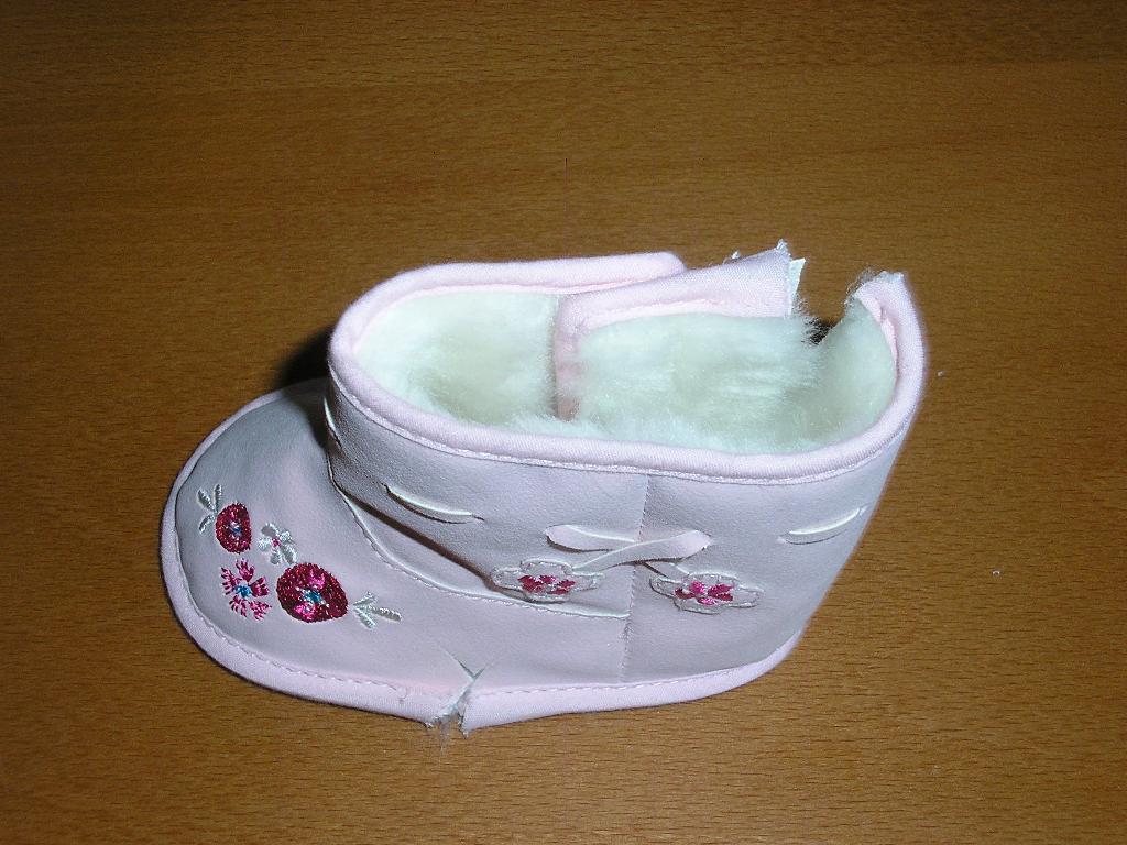 CHAUSSURE POUR BEBE,GENRE BOTTINE FOURRÉE, A DESSUS EN MATIERE PLASTIQUE (PVC) ET SEMELLE EXTERIEURE EN MATIERE TEXTILE COUVRANT LA CHEVILLE,AVEC UNE OUVERTURE SUR LE COTE SE FERMANT PAR UNE BANDE VELCRO. L'INTERIEUR DE LA CHAUSSURE EST EN FOURRURE SYNTHETIQUE.
DES MOTIFS FLORAUX SONT BRODÉS OU COUSUS SUR L'AVANT ET LE CÔTÉ DE LA BOTTINE.