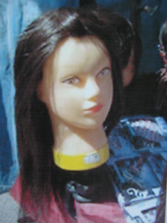 TÊTE A COIFFER EN MATIÈRE PLASTIQUE, COMPOSÉE DE CHEVEUX MAJORITAIREMENT NATURELS.