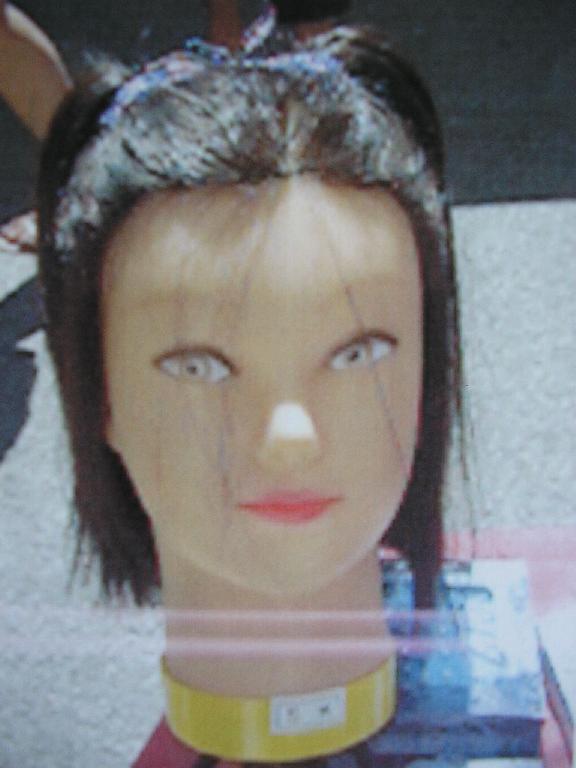 TÊTE A COIFFER EN MATIÈRE PLASTIQUE, COMPOSÉE DE CHEVEUX MAJORITAIREMENT SYNTHÉTIQUES.