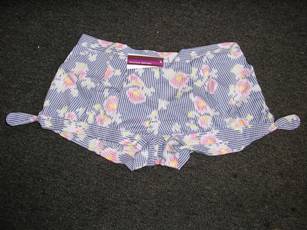 SHORT POUR FEMMES EN TISSU DE COTON (100% COTON), IMPRIME, MUNI D'UN ELASTIQUE A LA TAILLE AU NIVEAU DU DOS), DE PINCES SUR LE DEVANT, D'UNE POCHE LATERALE DE CHAQUE COTE. LA BASE COMPORTE UNE BANDE RAPPORTEE SE TERMINANT DE CHAQUE COTE PAR UN LIEN A NOUER AU NIVEAU DES FENTES.  

TAILLE 40.