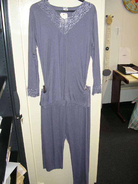 PYJAMA POUR FEMMES, EN ÉTOFFE DE BONNETERIE DE FIBRES SYNTHÉTIQUES (50% MODACRYLIQUE, 50% MODAL) COMPOSÉ :

- D'UN VÊTEMENT DE TYPE TEE-SHIRT, DESTINÉ A COUVRIR LA PARTIE SUPÉRIEURE DU CORPS, DE FACTURE AMPLE ET FLUIDE, DESCENDANT SOUS LES HANCHES, AVEC UNE ENCOLURE EN V DOTÉE D'UN LARGE GALON DE DENTELLE, AVEC DES MANCHES LONGUES DONT LES EXTRÉMITÉS SE TERMINENT ÉGALEMENT PAR UN GALON DE DENTELLE ET AGRÉMENTÉES D'UN PETIT NOEUD SATINÉ. EN OUTRE, LA BASE DU VÊTEMENT EST OURLÉE ET PRÉSENTE UNE FENTE SUR CHAQUE COTÉ.

- D'UN PANTALON DESTINÉ A COUVRIR LA PARTIE INFÉRIEURE DU CORPS, DESCENDANT JUSQU'AUX CHEVILLES, DE FACTURE LÉGÈRE, SANS OUVERTURE, AVEC UNE TAILLE ÉLASTIQUÉE. LA BASE DES JAMBES EST DOTÉE D'UN GALON DE DENTELLE IDENTIQUE A CELUI DU TEE-SHIRT.