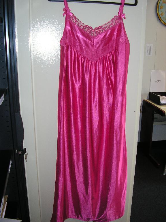 VÊTEMENT POUR FEMMES, GENRE NUISETTE, EN ÉTOFFE DE BONNETERIE DE FIBRES SYNTHÉTIQUES (100% POLYESTER), DE FACTURE LÉGÈRE, ASPECT SATIN, DESCENDANT JUSQU'AUX CHEVILLES, AVEC UN LÉGER DÉCOLLETÉ COMPORTANT UN GALON DE DENTELLE SUR LE DEVANT ET AU NIVEAU DE LA POITRINE, AVEC DE FINES BRETELLES RÈGLABLES DOTÉES CHACUNE D'UN PETIT NOEUD SATINÉ. EN OUTRE, LA BASE DU VÊTEMENT EST OURLÉE.