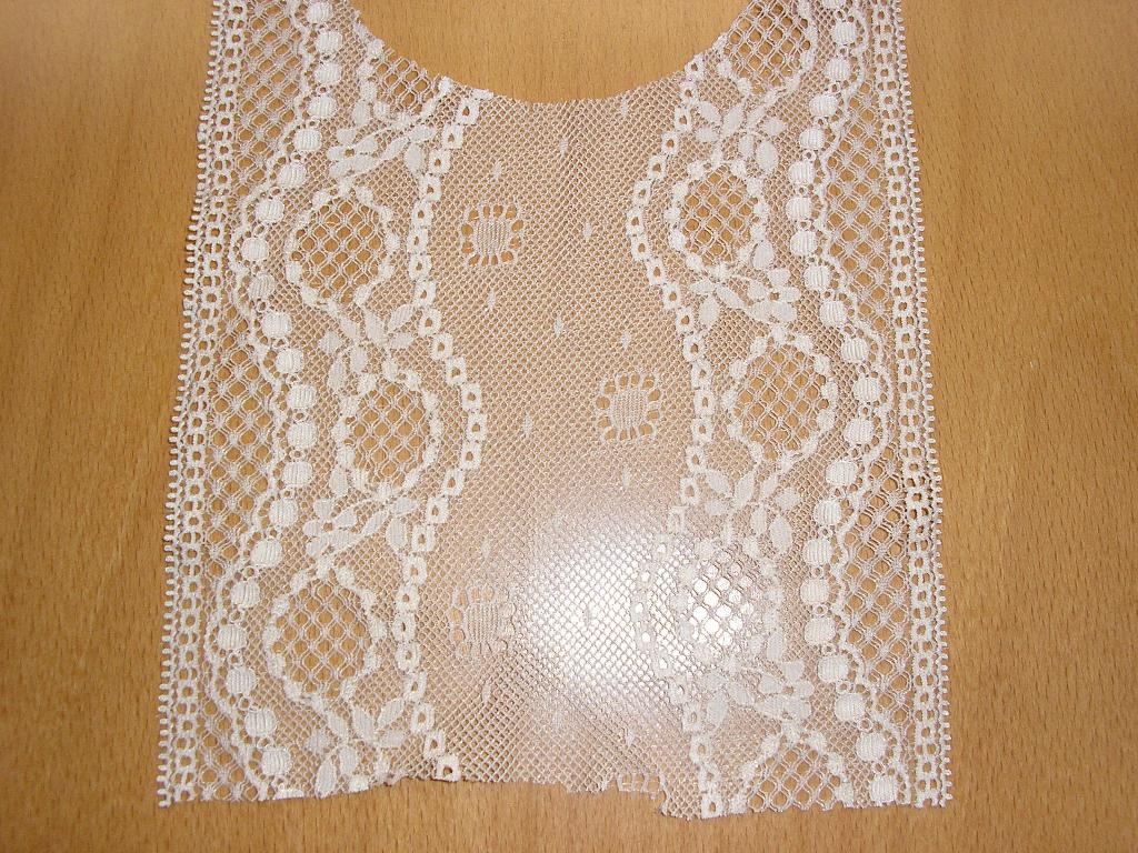 ÉTOFFE DE BONNETERIE DE FIBRES SYNTHÉTIQUES (73% POLYAMIDE, 27% ÉLASTHANNE), DE TYPE DENTELLE RASCHEL, SOUS LA FORME D'UNE BANDE ÉLASTIQUE DE 15,9 CM DE LARGEUR, AVEC DES MOTIFS BRODÉS.

POIDS : 112 GRAMMES/M²