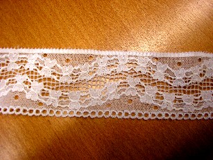 BANDE D'ETOFFE DE BONNETERIE, GENRE DENTELLE RASCHEL, DE FIBRES SYNTHETIQUES (84% POLYAMIDE, 16% ELASTHANNE), D'UNE LARGEUR DE 4 CM, COMPORTANT UN MOTIF FANTAISIE.