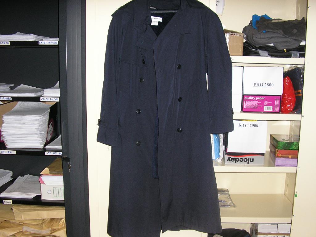 VÊTEMENT POUR FEMME DE TYPE IMPERMÉABLE, CONFECTIONNÉ EN TISSU DE FIBRES SYNTHÉTIQUES MAJORITAIRES (65% POLYESTER,35% COTON) DESCENDANT AU DESSOUS DU GENOU, AVEC UNE OUVERTURE COMPLÈTE SUR LE DEVANT SE FERMANT DROITE SUR GAUCHE AU MOYEN DE BOUTONS,AVEC UN BAVOLET FIXÉ PAR UN BOUTON,AVEC DES MANCHES LONGUES TERMINÉES PAR UNE PATTE MAINTENUE PAR UN BOUTON, AVEC DEUX POCHES SUR LE DEVANT,AVEC DES PATTES D'ÉPAULES,AVEC UNE CEINTURE A BOUCLE MAINTENUE A LA TAILLE PAR DEUX PASSANTS,AVEC UNE BASE OURLÉE.
DANS LE DOS, IL POSSÈDE UNE CAPUCHE AMOVIBLE FIXÉE SUR LE PIED DE COL PAR CINQ BOUTONS,UN DEUXIÈME BAVOLET AINSI QU'UNE FENTE PARTANT DU MILIEU DU DOS.
LE VÊTEMENT POSSÈDE UNE DOUBLURE INTÉRIEURE AMOVIBLE EN FAUSSE FOURRURE QUI EST FIXEE A L IMPERMÉABLE AU MOYEN D'UNE FERMETURE A GLISSIÈRE. 

POIDS: ENVIRON 1.300 KILOGRAMMES
