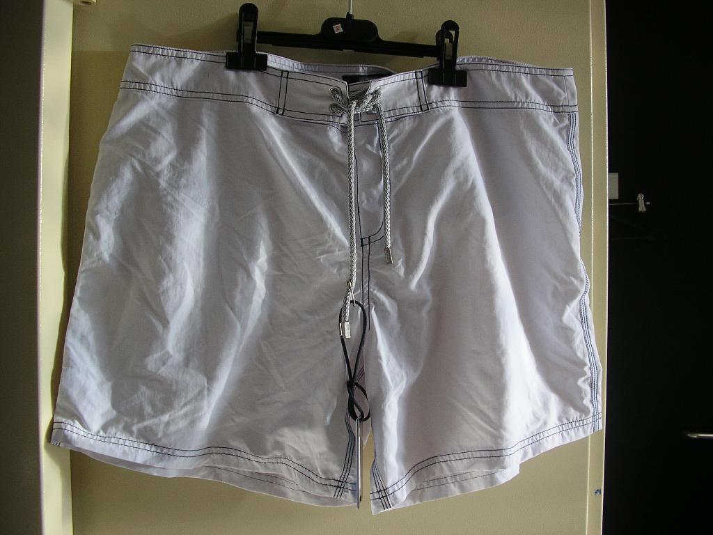 SHORT POUR HOMME, EN TISSU DE FIBRES SYNTHÉTIQUES (100% POLYAMIDE) DESCENDANT JUSQU'A MI-CUISSES, AVEC UNE OUVERTURE PARTIELLE SUR LE DEVANT SE FERMANT GAUCHE SUR DROITE AU MOYEN D'UNE BANDE VELCRO DISSIMULÉE SOUS UNE PATTE DE PROTECTION ET PAR UN LACET SE NOUANT SUR LE DEVANT, AVEC UNE DOUBLURE EN BONNETERIE ASPECT MAILLE-FILET FORMANT UN SLIP, ET UN OURLET À LA BASE. ENFIN, LE SHORT PRÉSENTE DES COUTURES DÉCORATIVES ET LE NOM DE LA MARQUE EST BRODÉ AU VERSO.