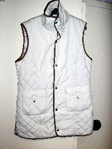 AUTRE VETEMENT, SIMILAIRE A UN GILET, POUR HOMMES, REMBOURRE, EN TISSU DE FIBRES SYNTHETIQUES (100% POLYESTER), AVEC DEUX BANDES MATELASSEES DEVANT SOUS LES EMMANCHURES, DESCENDANT SOUS LES HANCHES, AVEC UN COL MONTANT MATELASSE, SANS MANCHES, DOUBLE, AVEC UNE OUVERTURE COMPLÈTE SUR LE DEVANT SE FERMANT GAUCHE SUR DROITE PAR BOUTONS-PRESSION, AVEC UNE POCHE MUNIE D'UN RABAT ET D'UNE PATTE MAINTENUE PAR BOUTON-PRESSION, AVEC UN BIAIS CONTRASTE SUR LE POURTOUR DU VETEMENT, ET, AVEC UNE FENTE DE CHAQUE COTE DE LA BASE.