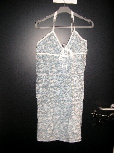 VETEMENT POUR FEMME DESTINÉ À RECOUVRIR LA PARTIE SUPÉRIEURE DU CORPS, LEGER, EN TISSU IMPRIME DE COTON MAJORITAIREMENT (60% COTON, 40% SOIE), DE TYPE ROBE, AVEC DES BRETELLES REGLABLES SE CROISANT DANS LE DOS MAINTENUES PAR UN BOUTON, DESCENDANT JUSQU'AU-DESSUS DE LA MI-CUISSE. CE VETEMENT PRESENTE UNE ENCOLURE ARRONDIE, UNE OUVERTURE PARTIELLE SUR LE DEVANT MAINTENUE PAR UN RUBAN A NOUER, UNE BANDE DE VOLANTS PLATS SUR LE POURTOUR DE L'ENCOLURE, UN RUBAN SOULIGNANT LA POITRINE ET SE PROLONGEANT DANS LE DOS, DES FRONCES AU NIVEAU DE LA POITRINE. LA BASE DU VETEMENT EST OURLEE.    

LONGUEUR : 87 CM ENVIRON 
TAILLE 40