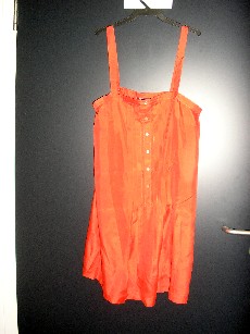 VETEMENT DESTINE A RECOUVRIR LE CORPS, GENRE ROBE, D'UNE LONGUEUR DE 90 CM, CONFECTIONNE EN TISSU 100% SOIE, SANS MANCHES, COMPORTANT UNE ENCOLURE DROITE, DES BRETELLES, UNE OUVERTURE PARTIELLE SUR LE DEVANT AU MILIEU LONGEE PAR DES PLIS AVEC DES BOUTONS SE FERMANT DE DROITE SUR GAUCHE, LA BASE DU VETEMENT SE TERMINE PAR UN LARGE OURLET.