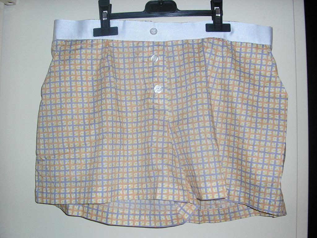 PETIT SHORT D’INTÉRIEUR, GENRE BOXER, CONFECTIONNÉ EN TISSU DE COTON, SANS OUVERTURE, ÉLASTIQUÉ DANS LE DOS, SANS DOUBLURE NI FOND INTERNE A L’ENTREJAMBE, AVEC UN OURLET A LA BASE, AVEC DEUX POCHES LATÉRALES, AVEC UNE BANDE RAPPORTÉE A LA TAILLE ET TROIS BOUTONS DÉCORATIFS SUR LE DEVANT.
