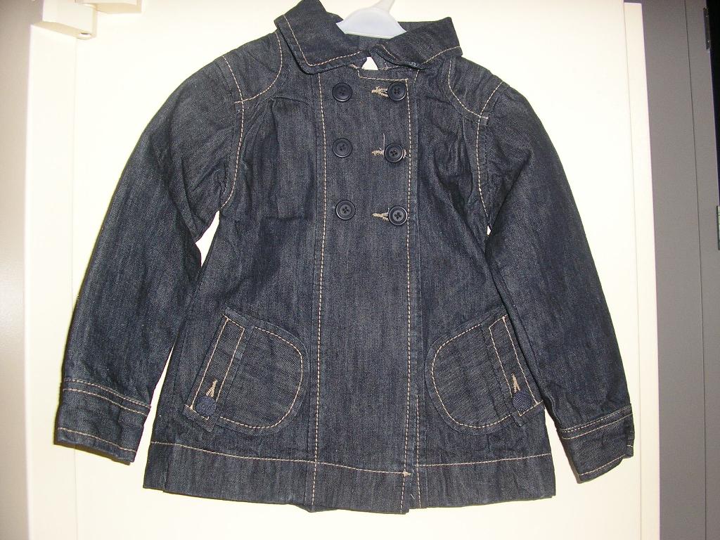 VESTE POUR FILLETTE, LÉGÈREMENT CINTRÉE, CONFECTIONNÉE EN TISSU DE COTON DE TYPE "DENIM", CONSTITUÉE D'UN PANNEAU DORSAL ET DE QUATRE PANNEAUX FRONTAUX, DESTINÉE A RECOUVRIR LA PARTIE SUPÉRIEURE DU CORPS, DESCENDANT JUSQU'AU DESSOUS DES HANCHES, AVEC UNE OUVERTURE COMPLÈTE SUR LE DEVANT SE FERMANT DROITE SUR GAUCHE AU MOYEN DE TROIS BOUTONS, AVEC UN COL CHEMISE, AVEC DES MANCHES LONGUES MUNIES D'UN POIGNET BOUTONNÉ, ET DEUX POCHES AU NIVEAU DE LA TAILLE POURVUES D'UN RABAT BOUTONNÉ. LA VESTE PRÉSENTE ÉGALEMENT UNE PETITE BOUTONNIÈRE SUR LE DEVANT, DES POINTS DE COUTURES DÉCORATIFS, UNE FENTE MÉDIANE DANS LE DOS ET UN OURLET À LA BASE.

TAILLE : 5 ANS