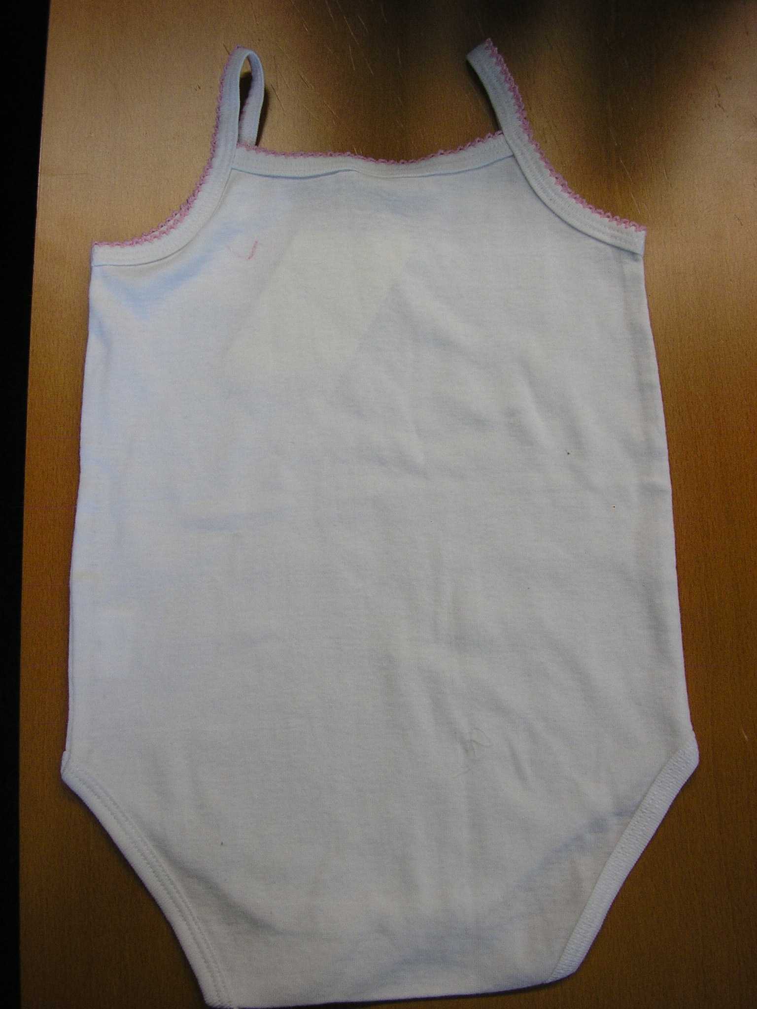 VÊTEMENT POUR ENFANT DESTINÉ A RECOUVRIR LE CORPS, GENRE BODY, EN ÉTOFFE DE BONNETERIE DE COTON, NON RECONNAISSABLE COMME ÉTANT POUR GARCONNET OU POUR FILLETTE, COMPORTANT DES FINES BRETELLES ET UN GALON FANTAISIE SUR TOUT LE POURTOUR DE L'ENCOLURE ET DES EMMANCHURES. LE VÊTEMENT PRÉSENTE ÉGALEMENT UN OURLET A LA BASE ET 
UNE OUVERTURE A L'ENTREJAMBE SE FERMANT AU MOYEN DE TROIS BOUTONS-PRESSION.

TAILLE : 36 MOIS