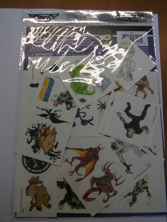 DÉCALCOMANIES POUR ENFANTS, GENRE TATOUAGES, REPRÉSENTANT DES PERSONNAGES COLORÉS, A COLLER A FROID SUR LA PEAU HUMIDIFIÉE. LES ARTICLES SONT POSÉS SUR UNE FEUILLE DE PAPIER D'UN COTÉ ET RECOUVERT D'UNE FEUILLE DE MATIÈRE PLASTIQUE TRANSPARENTE DE L'AUTRE COTÉ.

LES TATOUAGES SONT PRÉSENTÉS POUR LA VENTE AU DÉTAIL DANS UNE POCHETTE PLASTIFIÉE, ACCOMPAGNÉS D'UNE FEUILLE DE CARTON IMPRIMÉE. UNE NOTICE EST ÉGALEMENT IMPRIMÉE AU VERSO DE CHAQUE TATOUAGE.