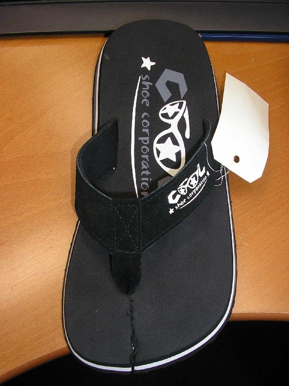 CHAUSSURE DE STYLE TONG,NON RECONNAISSABLE COMME ÉTANT POUR HOMME OU POUR FEMME,AVEC UN DESSUS CONSTITUÉ DE TROIS LANIÈRES EN CUIR COUSUES ENSEMBLE ET FIXÉES EN TROIS POINTS D'ANCRAGE A LA SEMELLE DONT UN ENTRE LE POUCE ET LES AUTRES ORTEILS,AVEC UN RENFORT (LANIÈRE TEXTILE EN NYLON)SITUÉ SOUS LA LANIÈRE EN CUIR FIXÉE A L'ENTREDOIGT ET UNE DOUBLURE EN BONNETERIE REMBOURRÉE D'EVA POUR LES DEUX AUTRES LANIÈRES FORMANT LA VÔUTE.
LA CHAUSSURE COMPORTE UNE SEMELLE INTÉRIEURE MESURANT AU MOINS 24 CM,AINSI QU'UNE SEMELLE ÉXTÉRIEURE EN MATIÈRE PLASTIQUE MOULÉE (EVA)COMPORTANT DES LOGOS SCULPTÉS DE LA MARQUE.