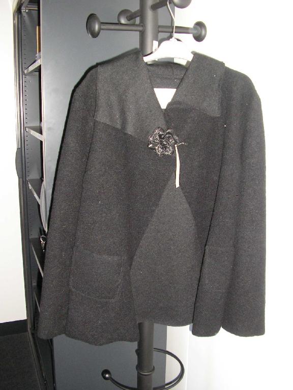 VÊTEMENT POUR FEMME DESCENDANT SUR LES HANCHES,DE TYPE VESTE,CONFECTIONNÉE EN BONNETERIE DE LAINE MAJORITAIRE (80% LAINE,20% POLYESTER),AVEC UN COL TOMBANT,AVEC DES MANCHES LONGUES,AVEC UNE OUVERTURE COMPLÈTE SUR LE DEVANT SE FERMANT DROITE SUR GAUCHE AU MOYEN D'UN BOUTON PRESSION,AVEC DEUX POCHES AU NIVEAU DES HANCHES.UNE FLEUR DÉCORATIVE ORNE LE COL DE LA VESTE. 

TAILLE 38/40