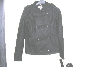 VESTE POUR FEMMES, CONFECTIONNÉE EN TISSU MAJORIATAIREMENT DE FIBRES ARTIFICIELLES ET NATURELLES (50% VISCOSE , 50% LAINE), AYANT DE LA TENUE, CONSTITUÉE DE SIX PANNEAUX FRONTAUX ET DE QUATRE PANNEAUX DORSAUX COUSUS ENSEMBLE DANS LE SENS DE LA LONGUEUR, DESCENDANT AUX HANCHES.  
ELLE COMPORTE UN COL DROIT, UNE OUVERTURE COMPLÈTE SUR LE DEVANT SE FERMANT DROITE SUR GAUCHE AU MOYEN D'UN DOUBLE  BOUTONNAGE, QUATRE PATTES DECORATIVES A BOUTONNER SUR LE DEVANT, DES MANCHES LONGUES,  UNE PETITE PATTE MUNIE D'UN BOUTON SUR LES EPAULES, DES POCHES ET UNE DOUBLURE.