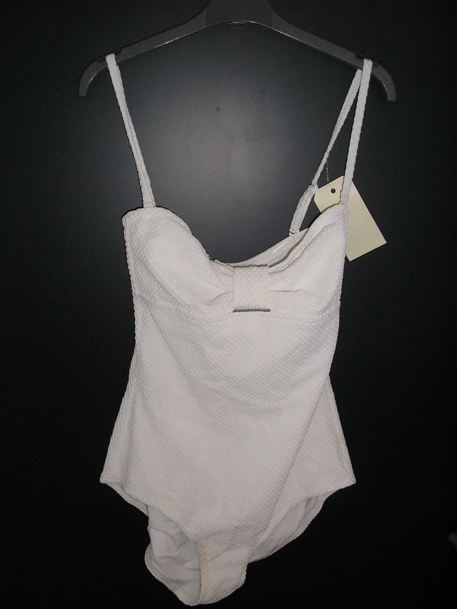 MAILLOT DE BAIN UNE-PIÈCE, POUR FEMMES, CONFECTIONNÉ EN TISSU DE FIBRES SYNTHÉTIQUES (87% POLYAMIDE, 13% ÉLASTHANNE), ASPECT "NID D'ABEILLE", ENTIÈREMENT DOUBLÉ, AVEC DES BONNETS MUNIS D'ARMATURES, ET DE FINES BRETELLES RÉGLABLES ET AMOVIBLES. CE MAILLOT DE BAIN PRÉSENTE UNE BANDE DU MÊME TISSU NOUÉ ENTRE LES DEUX BONNETS FORMANT UN NOEUD.