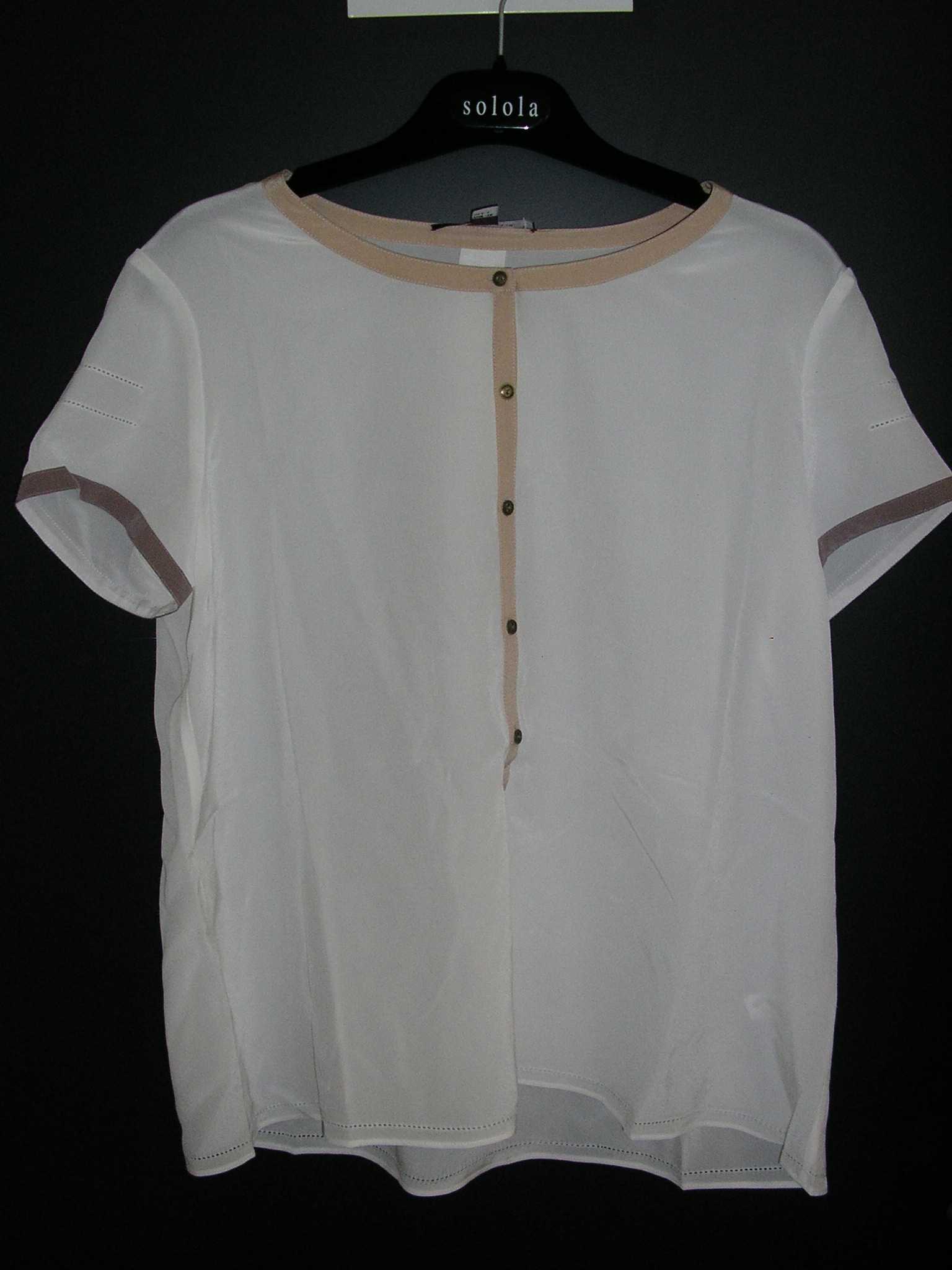 VÊTEMENT POUR FEMME, GENRE BLOUSE-CHEMISIER, CONFECTIONNÉ EN TISSU DE SOIE, DE FACTURE LÉGÈRE ET FLUIDE, DESTINÉ A COUVRIR LA PARTIE SUPÉRIEURE DU CORPS, AVEC UNE ENCOLURE ARRONDIE POURVUE D'UN BIAIS SUR TOUT LE POURTOUR, AVEC UNE OUVERTURE PARTIELLE SUR LE DEVANT SE FERMANT DROITE SUR GAUCHE AU MOYEN DE PETITS BOUTONS, AVEC DES MANCHES COURTES POURVUES D'UN BIAIS A LEUR EXTRÉMITÉ ET UN OURLET A LA BASE DU VÊTEMENT.