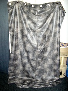 RIDEAU EN TISSU DE FIBRES SYNTHETIQUES (100% POLYESTER) COMPRENANT UN IMPRIME IMITANT LE CUIR VIEILLI, AVEC DES OEILLETS METALLIQUES PERMETTANT DE L'ACCROCHER.