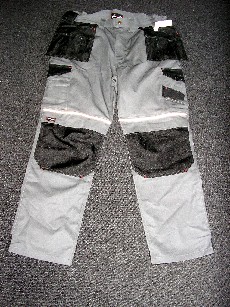 VETEMENT DE TRAVAIL, GENRE PANTALON, EN TISSU DE COTON MAJORITAIRE (65% COTON, 35% POLYESTER), POUR HOMMES, DESCENDANT JUSQU'AUX CHEVILLES EN ENVELOPPANT SÉPARÉMENT CHAQUE JAMBE, AVEC DES COUTURES SAFETY, UNE OUVERTURE PARTIELLE SUR LE DEVANT FERMANT GAUCHE SUR DROITE PAR FERMETURE A GLISSIERE, RABAT ET BOUTON, UN ELASTIQUE DE CHAQUE COTE DE LA TAILLE ET DES PASSANTS, DIFFERENTS TYPES DE POCHES AU NIVEAU DES HANCHES ET DES JAMBES SUR LE DEVANT ET DES POCHES PLAQUEES AU DOS, UN EMPLACEMENT AMENAGE AUX GENOUX POUR POSITIONNER UNE PROTECTION.