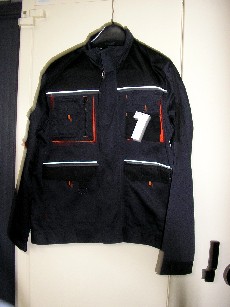 VETEMENT DESTINE A RECOUVRIR LA PARTIE SUPERIEURE DU CORPS, GENRE BLOUSON, CONFECTIONNE EN TISSU 65% POLYESTER ET 35% COTON, NON DOUBLE, COMPORTANT UN COL MONTANT, UNE OUVERTURE COMPLETE SUR LE DEVANT AU MILIEU AVEC UNE FERMETURE A GLISSIERE, UNE PATTE DE PROTECTION SE FERMANT DE GAUCHE SUR DROITE AVEC DES BANDES VELCRO, DES MANCHES LONGUES AVEC UNE PETITE POCHE SUR LE HAUT, DONT LES EXTREMITES SONT REGLABLENT PAR PATTE DE SERRAGE AVEC BANDE VELCRO, UNE POCHE A SOUFFLET AVEC DES COMPARTIMENTS DE CHAQUE COTE DE LA POITRINE, UNE GRANDE POCHE DOUBLEE AVEC RABAT DE CHAQUE COTE DU VETEMENT.