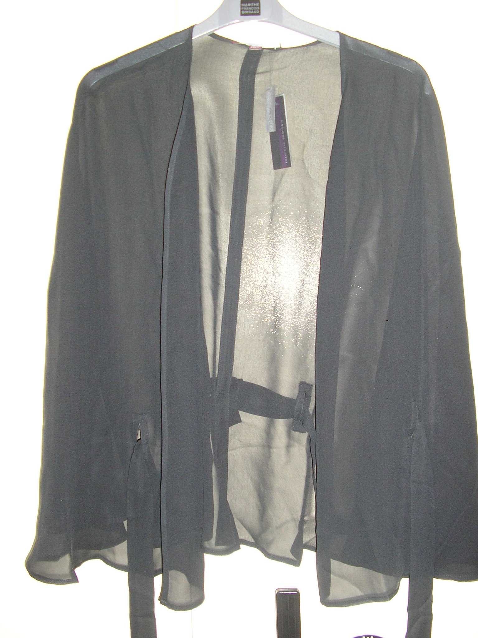 AUTRE VÊTEMENT POUR FEMME, DE TYPE CAPE TRANSPARENTE, CONFECTIONNÉE EN TISSU 100% SOIE, COMPRENANT UNE OUVERTURE TOTALE SUR LE DEVANT FERMÉE PAR UN LIEN A NOUER AU NIVEAU DE LA TAILLE, AVEC DES MANCHES DE TYPE CHAUVE-SOURIS, AVEC QUATRE PASSANTS DONT DEUX DANS LE DOS ET UN SUR CHAQUE PANNEAU AVANT. CE SYSTÈME DE LIEN A NOUER PERMET AINSI DE MAINTENIR LE VÊTEMENT SUR LES ÉPAULES.

TAILLE:40