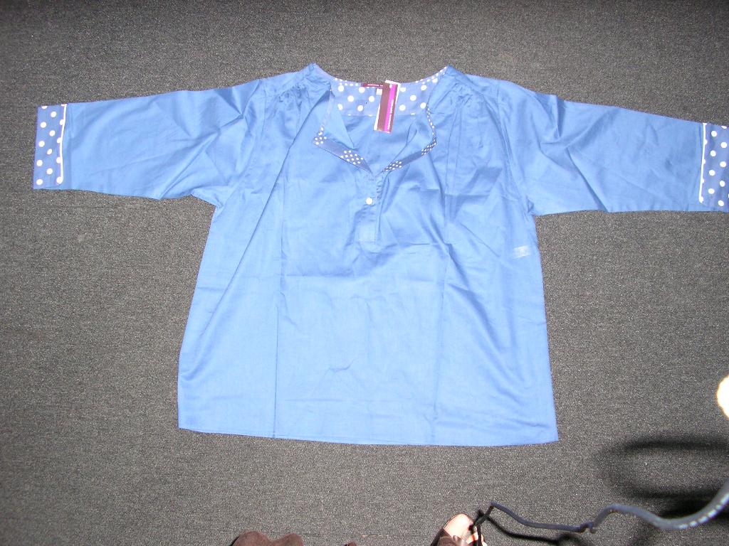VÊTEMENT POUR FEMME, DE TYPE BLOUSE,CONFECTIONNÉ EN TISSU 100% COTON AVEC UNE ENCOLURE RONDE DOTÉE D'UNE OUVERTURE PARTIELLE SE FERMANT DROITE SUR GAUCHE AU MOYEN D'UN BOUTON,AVEC DES MANCHES TROIS-QUART RETOURNEES A L'EXTREMITE,AVEC UN LÉGER OURLET A LA BASE DU VÊTEMENT. LA BLOUSE COMPORTE UN IMPRIMÉ A POIS AU NIVEAU DES MANCHES ET DE L'ENCOLURE.

TAILLE 40