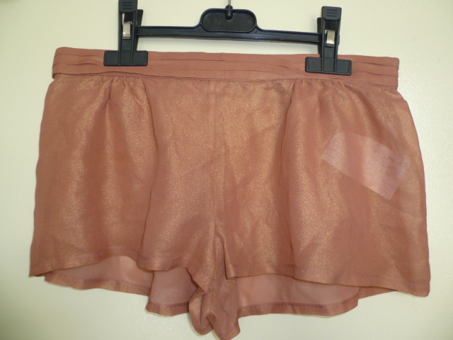 PETIT SHORT D'INTÉRIEUR POUR FEMMES, GENRE BOXER, SANS DOUBLURE ET SANS OUVERTURE, CONFECTIONNÉ EN TISSU DE SOIE, DE FACTURE AMPLE ET LÉGÈREMENT TRANSPARENT, AVEC DES IMPRESSIONS IRISÉES. LE VÊTEMENT COMPORTE TROIS RANGÉES DE PLIS HORIZONTAUX A LA TAILLE, UNE BANDE ÉLASTIQUE SOUS TUNNEL DANS LE DOS, DES FRONCES DÉCORATIVES SOUS LA TAILLE ET DANS LE DOS ET UN OURLET À LA BASE DES JAMBES.