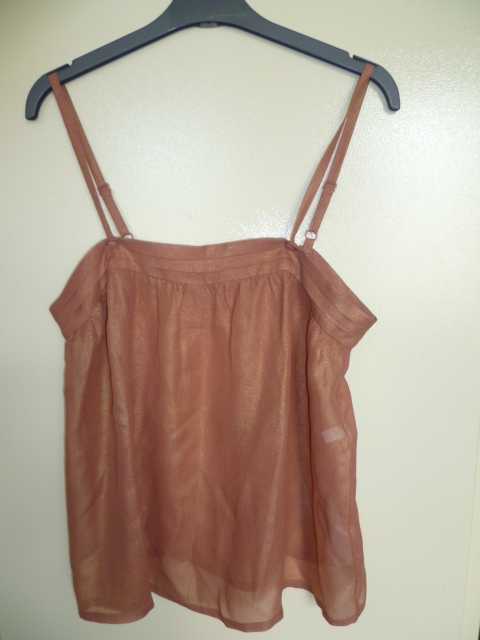 BLOUSE POUR FEMMES, GENRE CARACO, CONFECTIONNÉ EN TISSU DE SOIE, DESTINÉ A RECOUVRIR LE HAUT DU CORPS, DESCENDANT JUSQU'AUX HANCHES, AVEC DES IMPRESSIONS IRISÉES, LÉGÈREMENT TRANSPARENTE ET DE FACTURE FLUIDE. CE VÊTEMENT COMPORTE DE FINES BRETELLES RÈGLABLES, UNE ENCOLURE DROITE MUNIE DE TROIS RANGÉES DE PLIS HORIZONTAUX, DES FRONCES DÉCORATIVES SOUS L'ENCOLURE ET AU DOS ET UN OURLET A LA BASE.