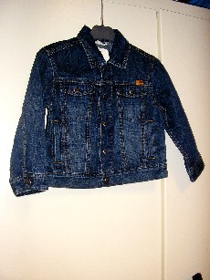 VETEMENT DESTINE A RECOUVRIR LA PARTIE SUPERIEURE DU CORPS, GENRE VESTE, POUR GARCONS, EN TISSU 100% COTON, ASPECT DENIM, SANS DOUBLURE, COMPORTANT UN COL CHEMISIER, UNE OUVERTURE COMPLETE SUR LE DEVANT AU MILIEU AVEC DES BOUTONS-PRESSIONS SE FERMANT DE GAUCHE SUR DROITE, DES MANCHES LONGUES AVEC UN BOUTON AUX EXTREMITES, UNE POCHE AVEC RABAT ET BOUTON-PRESSION DE CHAQUE COTE DE LA POITRINE, UNE POCHE VERTICALE DE CHAQUE COTE DU VETEMENT, LA BASE EST OURLEE, AVEC LOGO PUBLICITAIRE COUSU AU BAS DU DOS ET SUR LA POITRINE COTE GAUCHE, DECORATION SURPIQURES APPARENTES DE COULEUR.