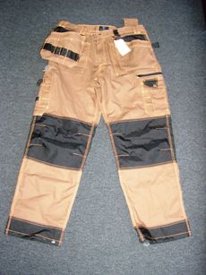 VETEMENT DE TRAVAIL, GENRE PANTALON, EN TISSU DE COTON MAJORITAIRE (60% COTON, 40% POLYESTER), BICOLORE, POUR HOMMES, DESCENDANT JUSQU'AUX CHEVILLES EN ENVELOPPANT SÉPARÉMENT CHAQUE JAMBE,  AVEC DES COUTURES SAFETY, AVEC UNE OUVERTURE PARTIELLE SUR LE DEVANT FERMANT GAUCHE SUR DROITE PAR FERMETURE A GLISSIERE,  RABAT ET BOUTON, AVEC DES PASSANTS A LA TAILLE ET UNE PETITE SANGLE AVEC UNE BOUCLE SUR LE DEVANT ET AU DOS  , AVEC DIFFERENTS TYPES DE POCHES AU NIVEAU DES HANCHES ET DES JAMBES SUR LE DEVANT : POCHES AMOVIBLES, POCHES PLAQUEES, POCHES AVEC FERMETURE A GLISSIERE, POCHES A RABAT ET BOUTON PRESSION, AVEC UNE BANDE DE TISSU COUSUE AU NIVEAU DES GENOUX FAISANT LE TOUR DE LA JAMBE ET A LA BASE, AVEC DEUX POCHES PLAQUEES ET UNE POCHE VOLANTE AU DOS, AVEC TROIS PASSANTS COUSUS SUR LE COTE DROIT ET UN A GAUCHE.