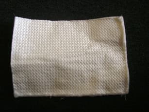 PLAQUE REFRACTAIRE SOUPLE DE 5 MM D'EPAISSEUR COMPORTANT UNE FACE ALUMINISEE GAUFFREE ET UNE FACE CONSTITUEE D'UNE NAPPE DE FIBRES COUSUES EN SILICE ET ZIRCONIUM. CET ARTICLE RESISTANT A 1500°C EST DESTINE A LA PROTECTION THERMIQUE.